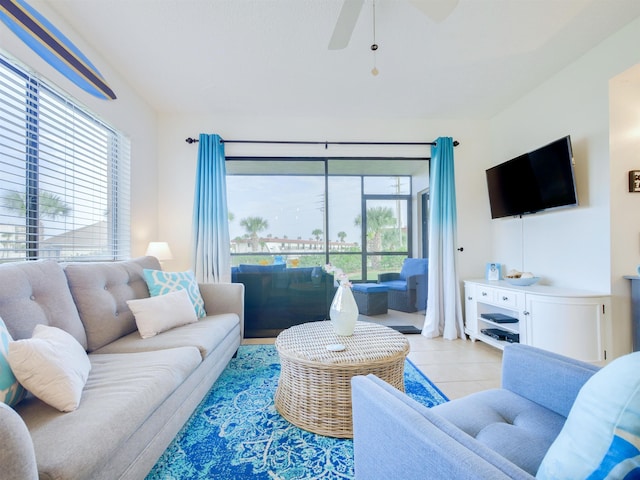 living area with light tile patterned floors and a ceiling fan