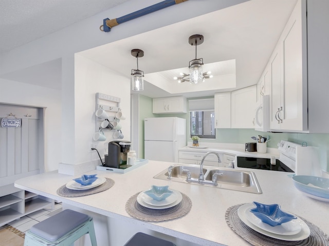 kitchen featuring a sink, a tray ceiling, white cabinetry, white appliances, and light countertops