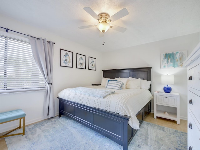 bedroom with light tile patterned floors, baseboards, and a ceiling fan