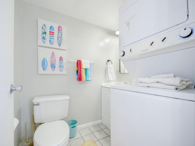 bathroom with toilet, stacked washer and clothes dryer, tile patterned flooring, baseboards, and vanity