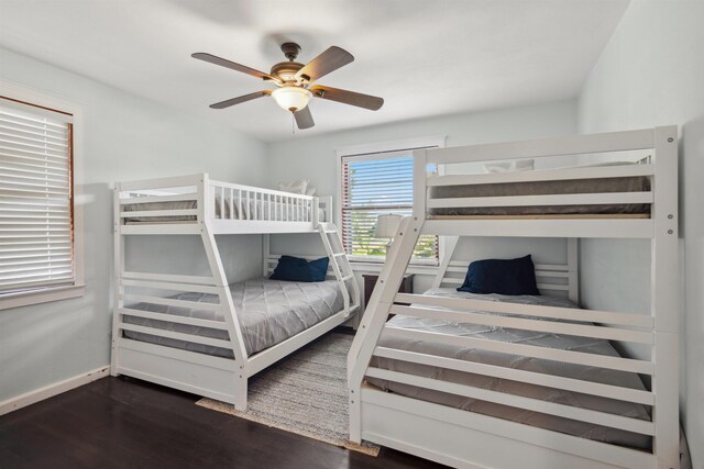 bedroom with dark wood-style floors, baseboards, and ceiling fan