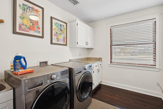 laundry room with visible vents, dark wood-style floors, cabinet space, baseboards, and washing machine and clothes dryer