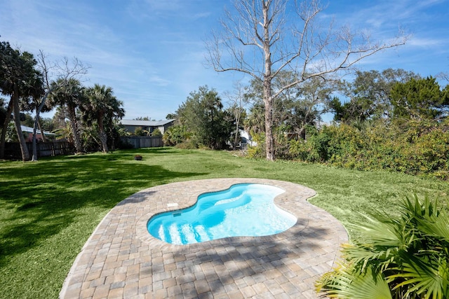 view of swimming pool with a yard and fence