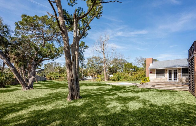 view of yard with french doors and a wooden deck