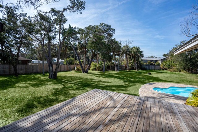 wooden terrace featuring a yard, a fenced backyard, and a fenced in pool