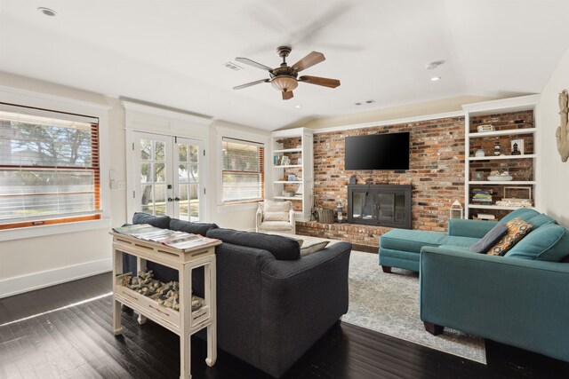 living room featuring dark wood finished floors, french doors, baseboards, a brick fireplace, and vaulted ceiling