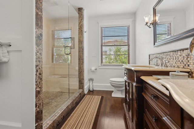 full bath with vanity, wood finished floors, baseboards, a stall shower, and toilet