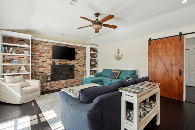 living area with visible vents, lofted ceiling, dark wood-type flooring, and a barn door