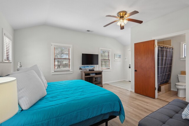 bedroom with ceiling fan, visible vents, light wood-style flooring, and vaulted ceiling