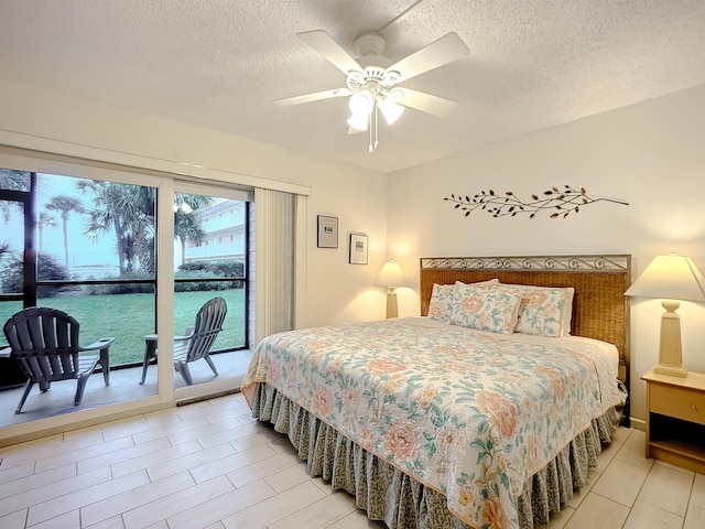 bedroom with ceiling fan, access to exterior, and a textured ceiling