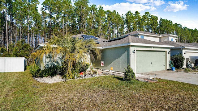 view of front of home featuring solar panels, a garage, and a front lawn