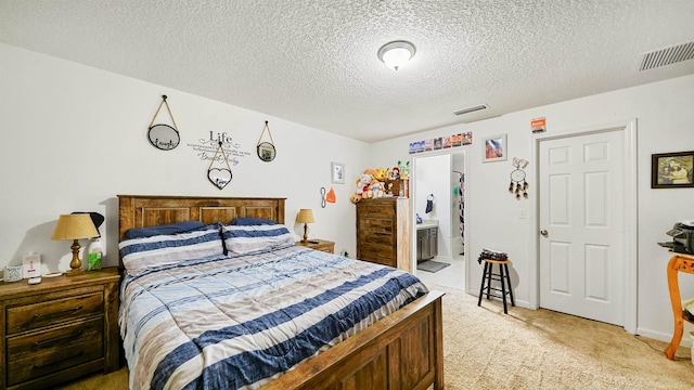 carpeted bedroom with a textured ceiling and connected bathroom