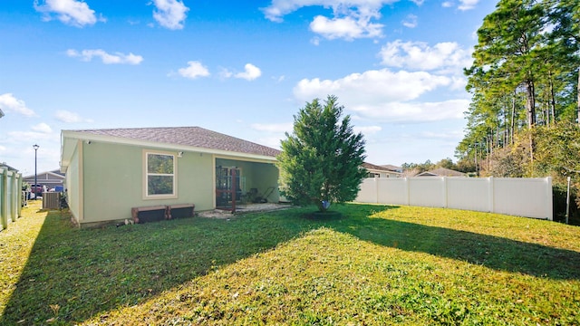 rear view of house featuring a yard and central AC