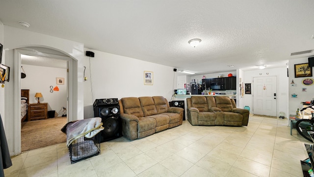 living room with a textured ceiling and light colored carpet