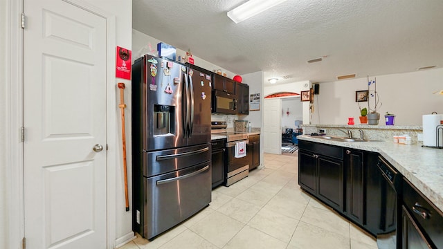 kitchen featuring sink, light tile patterned flooring, black appliances, and a textured ceiling