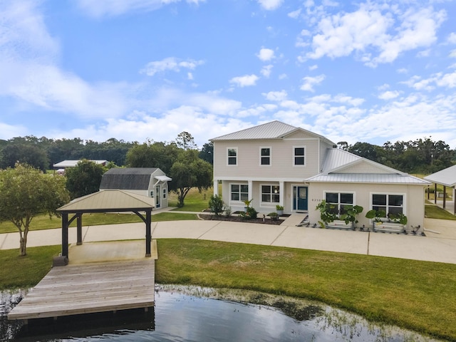 back of house with a gazebo, a water view, and a lawn