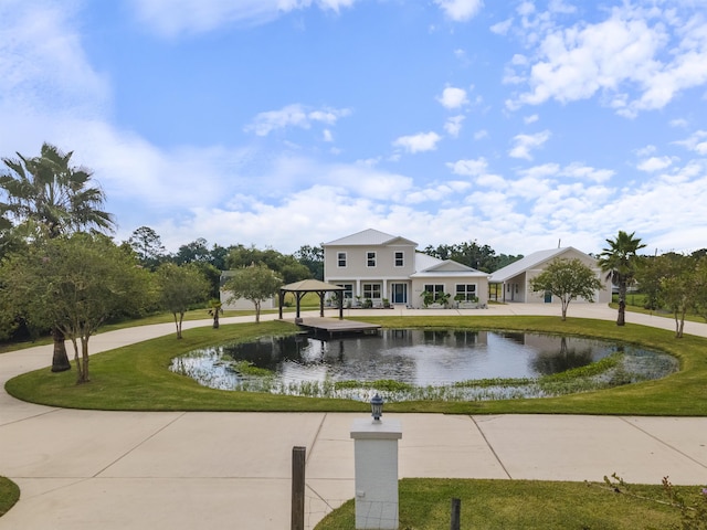 surrounding community featuring a gazebo, a water view, and a lawn