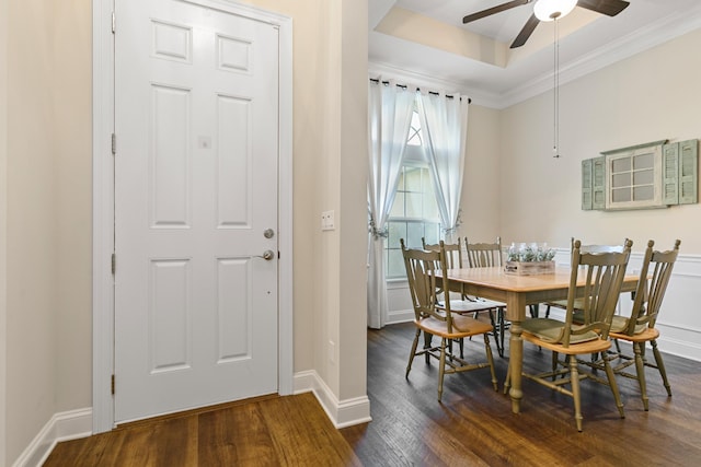 dining area featuring dark hardwood / wood-style flooring, a raised ceiling, ceiling fan, and crown molding