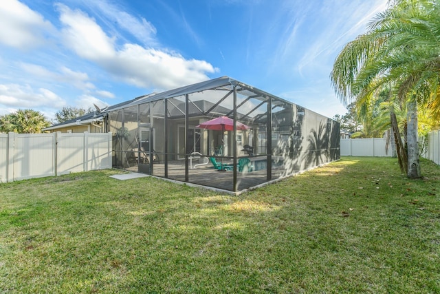 exterior space featuring a patio, a yard, a fenced in pool, and glass enclosure