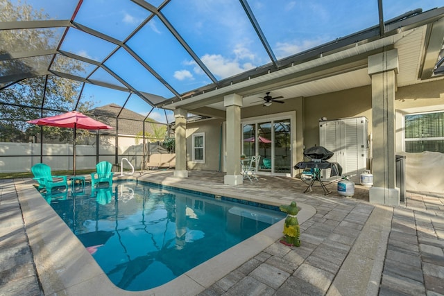 view of swimming pool with a patio area, ceiling fan, glass enclosure, and grilling area