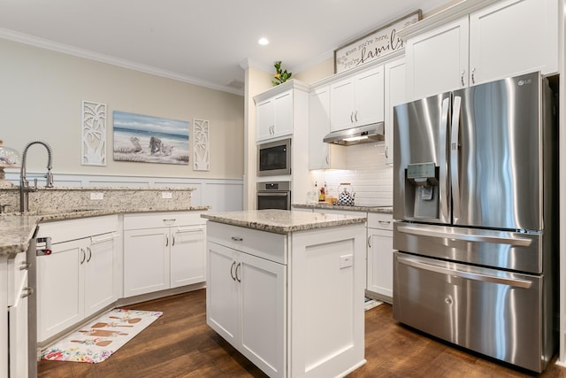 kitchen with dark wood-type flooring, white cabinets, sink, light stone countertops, and appliances with stainless steel finishes