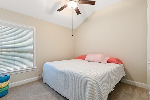 carpeted bedroom with ceiling fan and vaulted ceiling