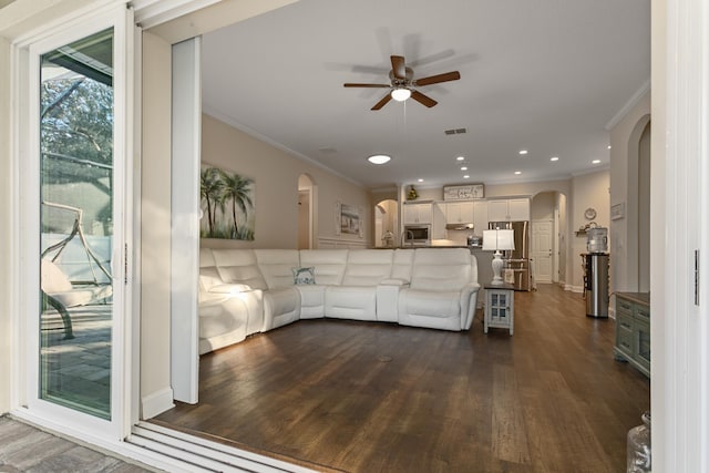 living room with ceiling fan, dark hardwood / wood-style flooring, and ornamental molding