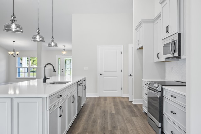 kitchen with white cabinetry, sink, an island with sink, decorative light fixtures, and appliances with stainless steel finishes