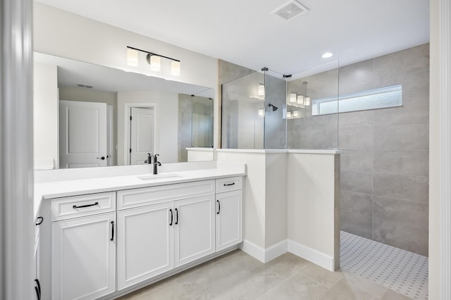 bathroom featuring tiled shower and vanity