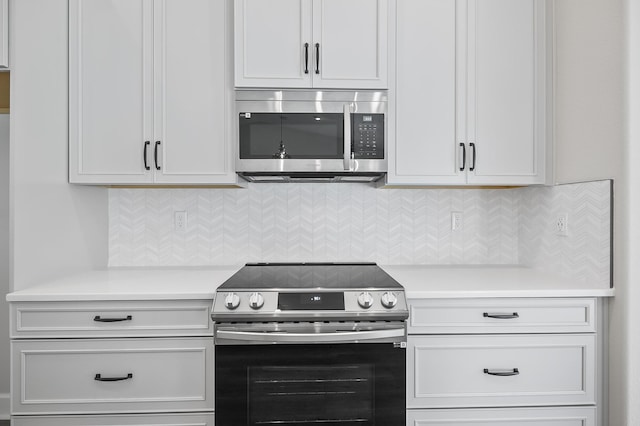 kitchen with white cabinets, backsplash, and stainless steel appliances