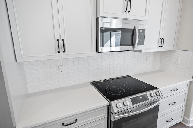 kitchen with white cabinets, stainless steel appliances, and tasteful backsplash