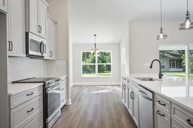 kitchen featuring pendant lighting, plenty of natural light, sink, and stainless steel appliances