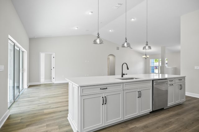 kitchen featuring hanging light fixtures, sink, a kitchen island with sink, and vaulted ceiling