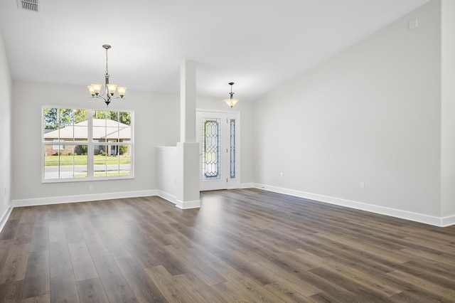 unfurnished living room with dark wood-type flooring and a notable chandelier