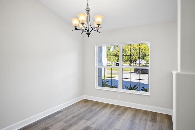 empty room with a chandelier and hardwood / wood-style floors