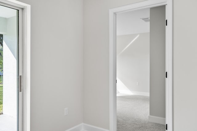 hall with carpet and a healthy amount of sunlight