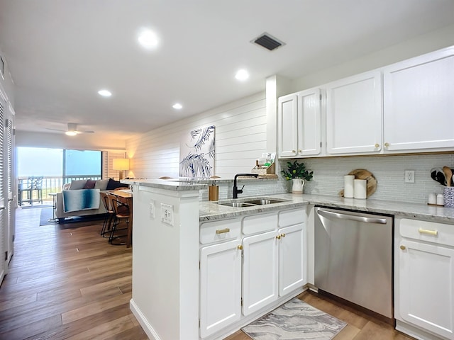 kitchen featuring white cabinets, dishwasher, kitchen peninsula, and sink