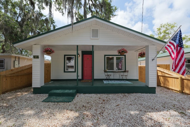 view of front facade featuring covered porch and fence