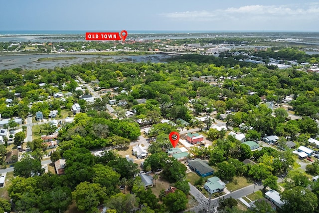 aerial view of residential area featuring a large body of water and a tree filled landscape