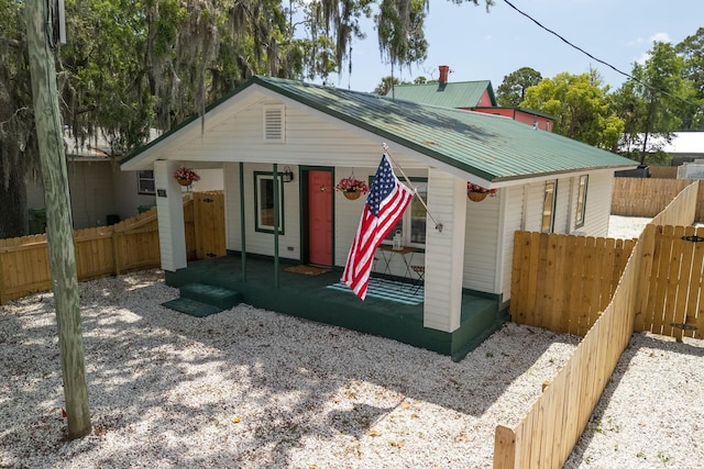view of front facade with a fenced backyard and metal roof