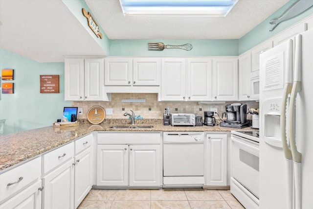 kitchen with white cabinets, sink, white appliances, and a textured ceiling