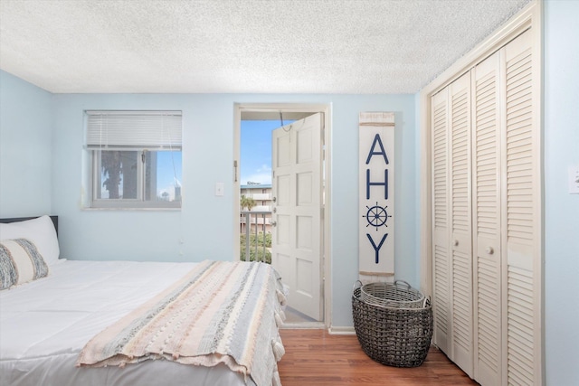 bedroom featuring a closet, hardwood / wood-style floors, and a textured ceiling