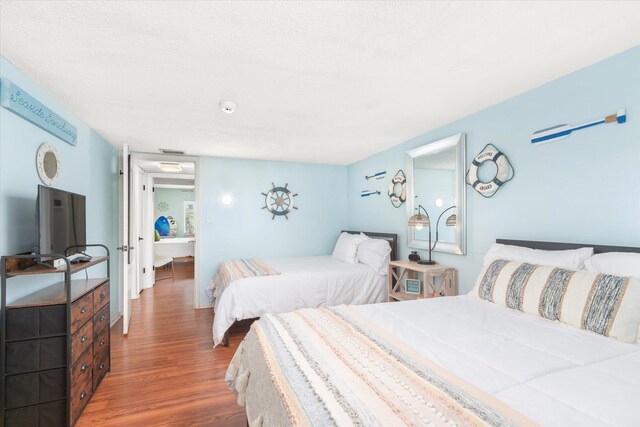 bedroom with wood-type flooring and a textured ceiling