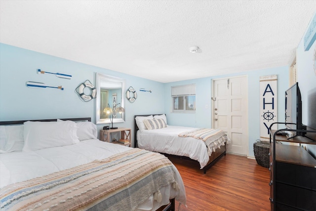 bedroom with dark hardwood / wood-style flooring and a textured ceiling