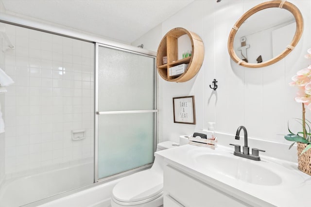 full bathroom with vanity, a textured ceiling, toilet, and enclosed tub / shower combo