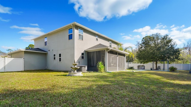 rear view of house with a yard, a fenced backyard, a sunroom, and central air condition unit