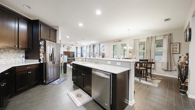 kitchen featuring light countertops, visible vents, backsplash, appliances with stainless steel finishes, and a sink