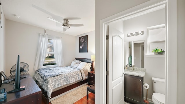 bedroom with ceiling fan, a sink, and wood finished floors