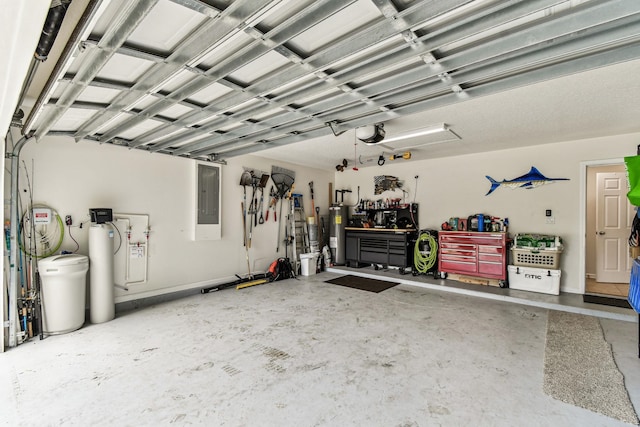 garage with electric panel, a workshop area, water heater, and a garage door opener