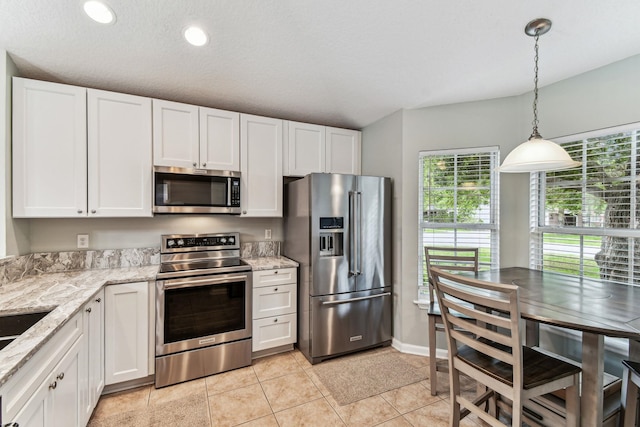 kitchen featuring stainless steel appliances, white cabinets, light stone countertops, pendant lighting, and recessed lighting